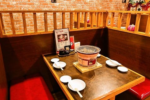 「炭火焼肉 ジンギスカン食べ放題 まんぷくカルビ 上野店」店内の半個室風テーブル