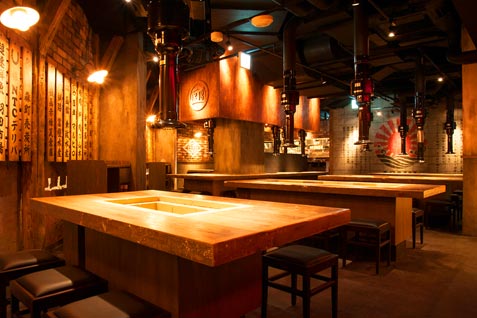 「銭函バーベキュー 銀座店」の炭火焼きテーブルを配した店内