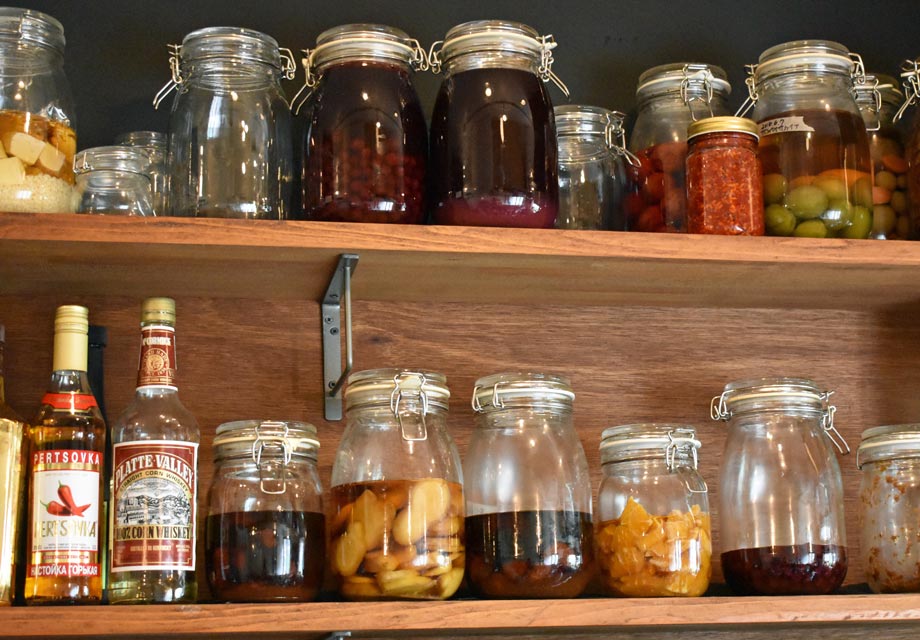 「リサバル 家庭料理とお酒いろいろ」の棚に並ぶ自家製食材の数々