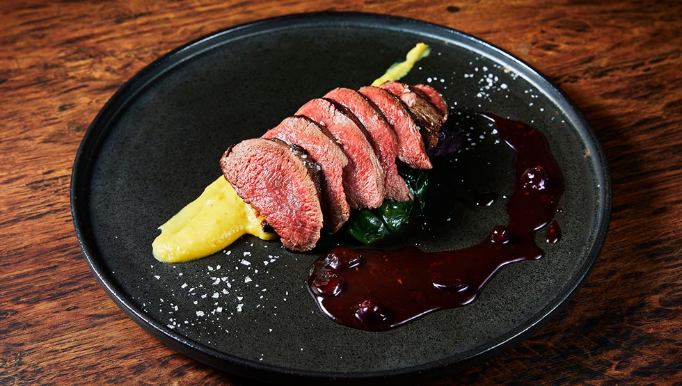 『欧風小皿料理 沢村』の「鹿もも肉のステーキ グリーンペッパーとカシスのソース」