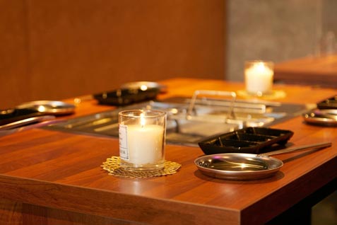 『大阪焼肉 食べ放題 焼肉エイト 梅田茶屋町店』のテーブル席と無煙ロースター